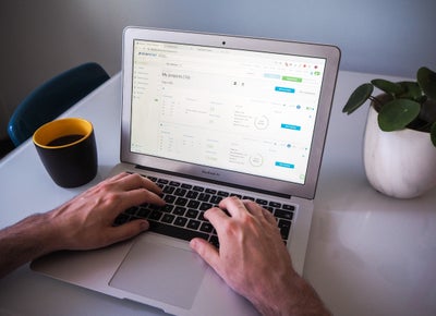 Person working on a computer drinking coffee